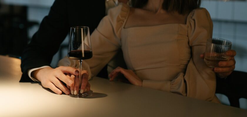 Woman in Beige Long Sleeve Shirt Holding Wine Glass